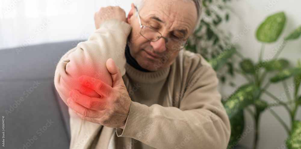 Guy holding hand to shoulder of aches, with red spot indicating location. Guy holding hand to shoulder of aches, with red spot indicating location.