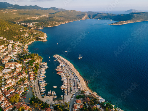 Fototapeta Naklejka Na Ścianę i Meble -  Aerial drone shot of Kaş center and marina, highlighting the vibrant coastal landscape, turquoise waters, and Mediterranean architecture in Antalya, Turkey.