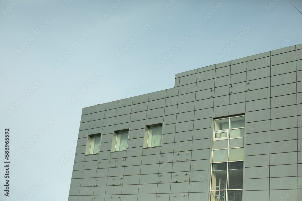 Obraz premium Modern building is gray in color. Facing panel on office building.