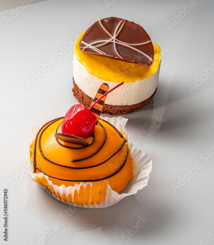 Various cakes with fruit jelly chocolate decoration. Exquisite Fresh delicious mousse dessert on white background with shadow. photo