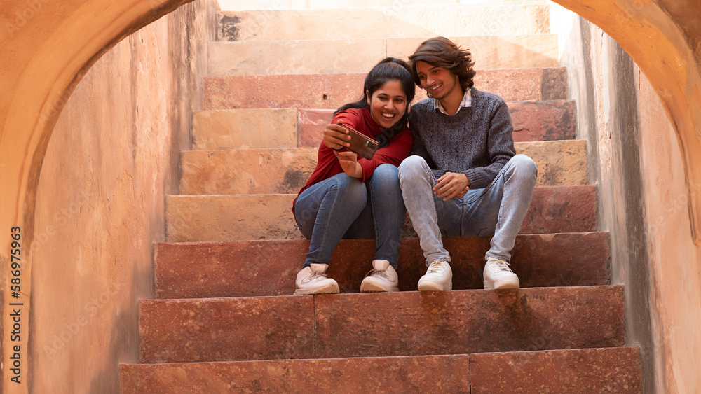 couple sitting on the steps taking selfie