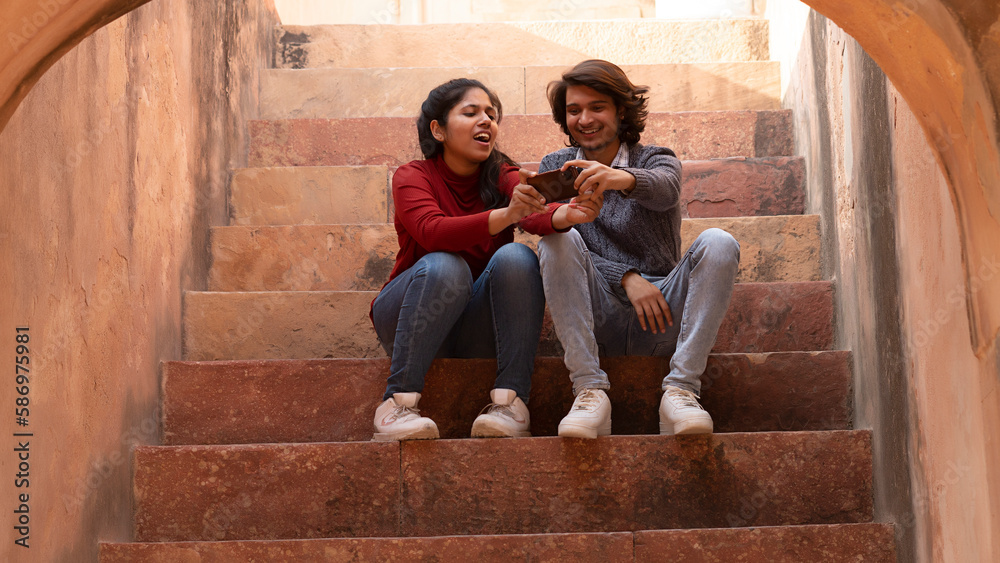 couple sitting on the steps taking selfie