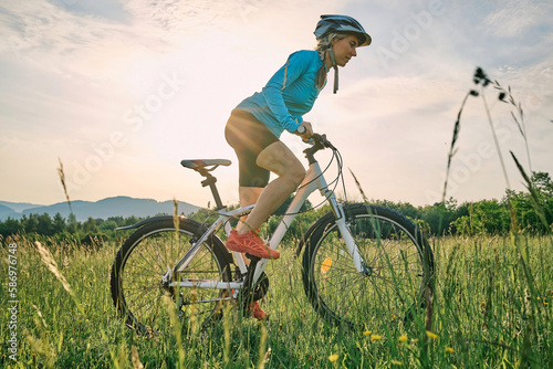 Cyclist Woman riding bike go in sports outdoors on sunny day a mountain in the forest. Silhouette female at sunset. Fresh air. Health care, authenticity, sense of balance and calmness. 