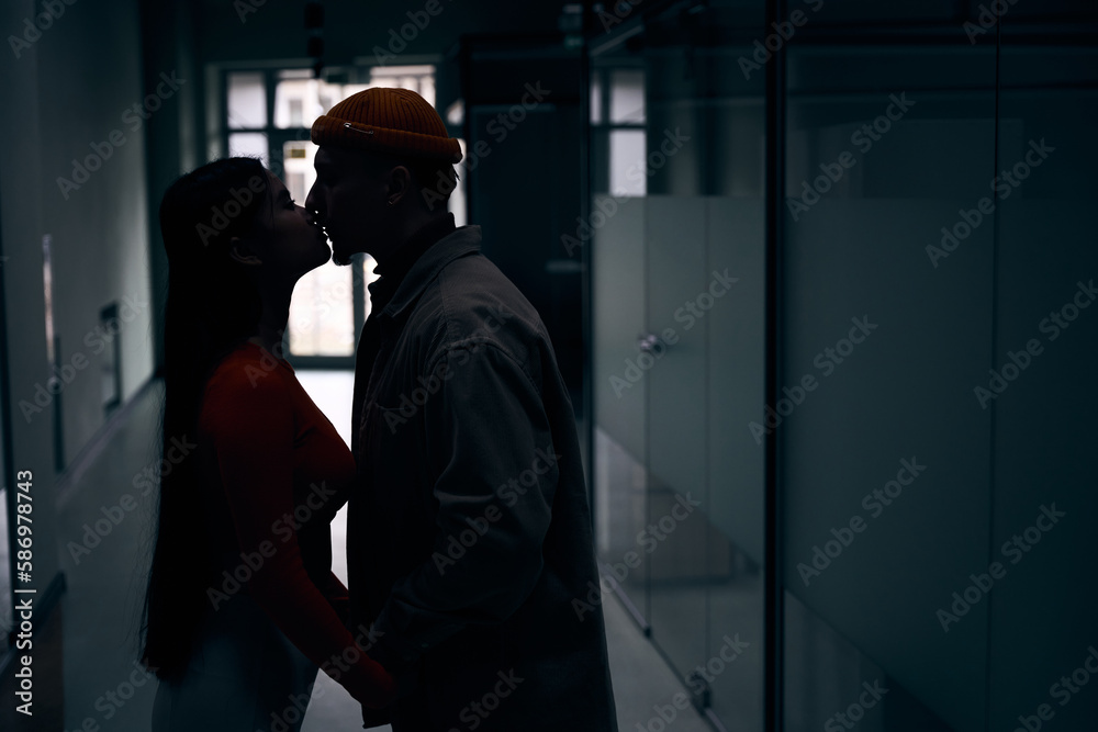 Couple giving kiss to each other in office building