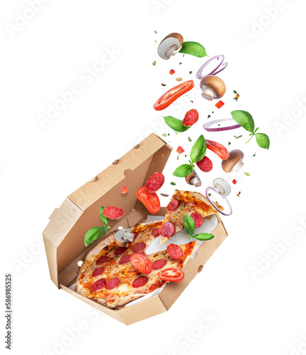 Freshly baked spicy pizza with various food ingredients in the air