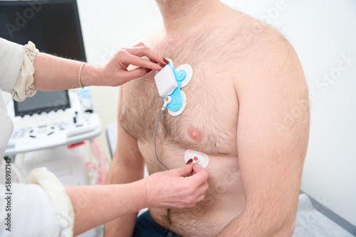 Male patient with sensors on his body to monitor arrhythmia photo