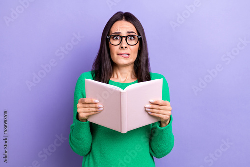 Photo of shocked funny woman wear green pullover spectacles reading scary book isolated purple color background