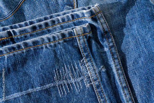 Details of blue jeans - hem with decorative seams close up
