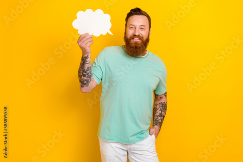 Portrait of cheerful attractive man wear stylish green clothes hold bubble shape element empty space isolated on yellow color background