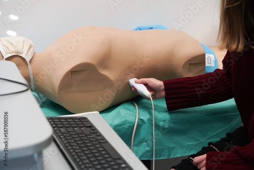 Students and their teacher during an echography simulation workshop on a robot mannequin.