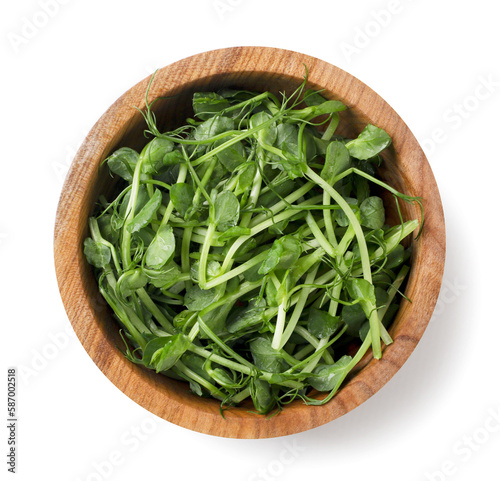 Micro greens in a wooden plate on a white background. Top view