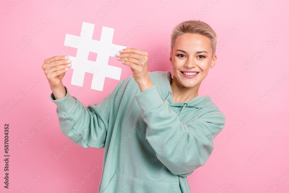 Photo portrait of lovely young lady hold paper hashtag successful marketer blogger wear trendy khaki look isolated on pink color background Photo portrait of lovely young lady hold paper hashtag successful marketer blogger wear trendy khaki look isolated on pink color background