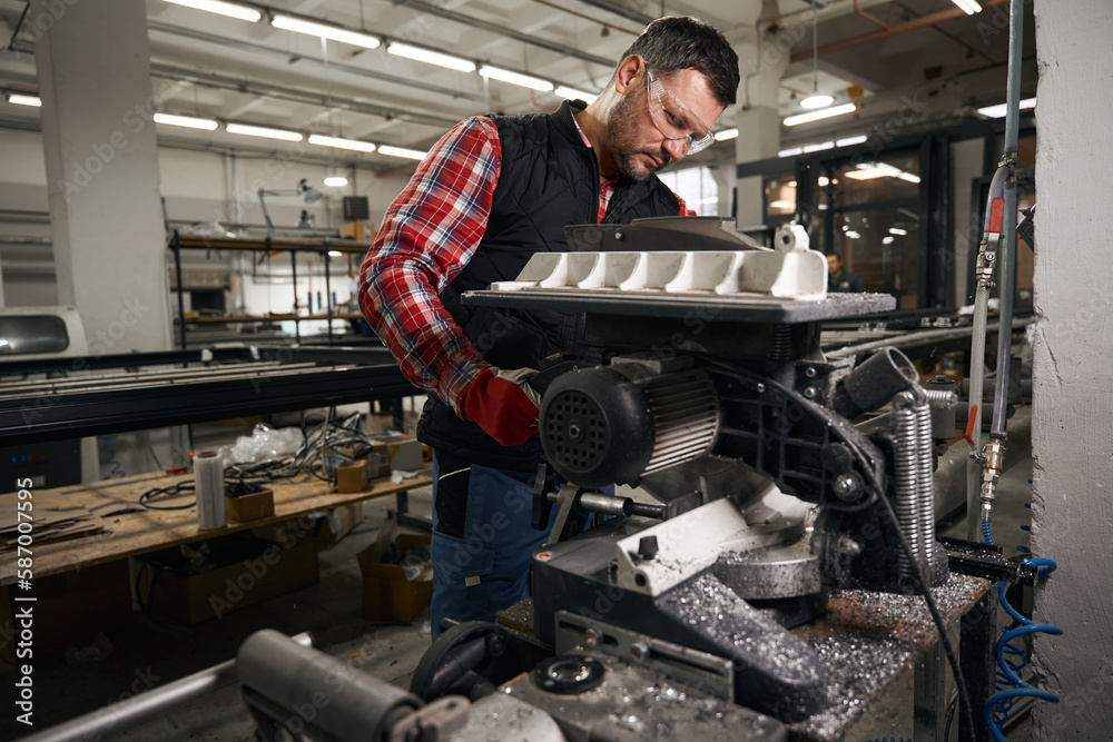 Adult man supervising the operation of the equipment