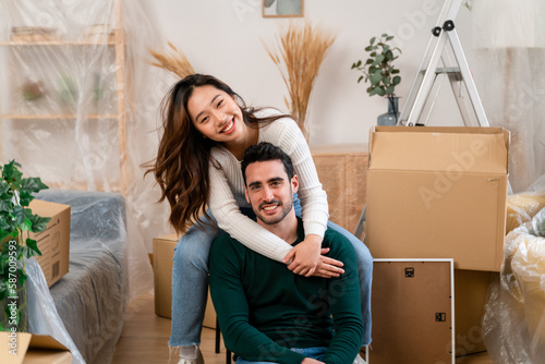 Happy young man and woman smiling and hugging and looking at camera 