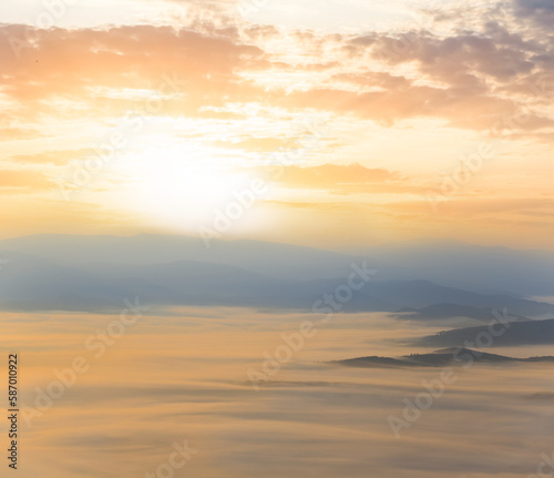 mountain valley in dense mist at the sunrise, early morning mountain landscape