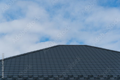 The roof is made of black metal tiles. Roof metal sheets