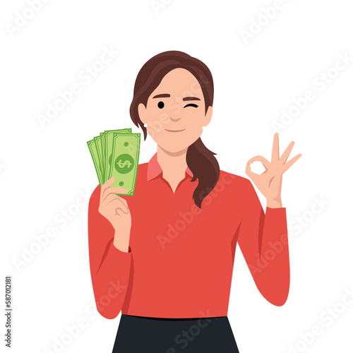 Young woman holding cash or currency or money in hand and showing OKAY or OK sign