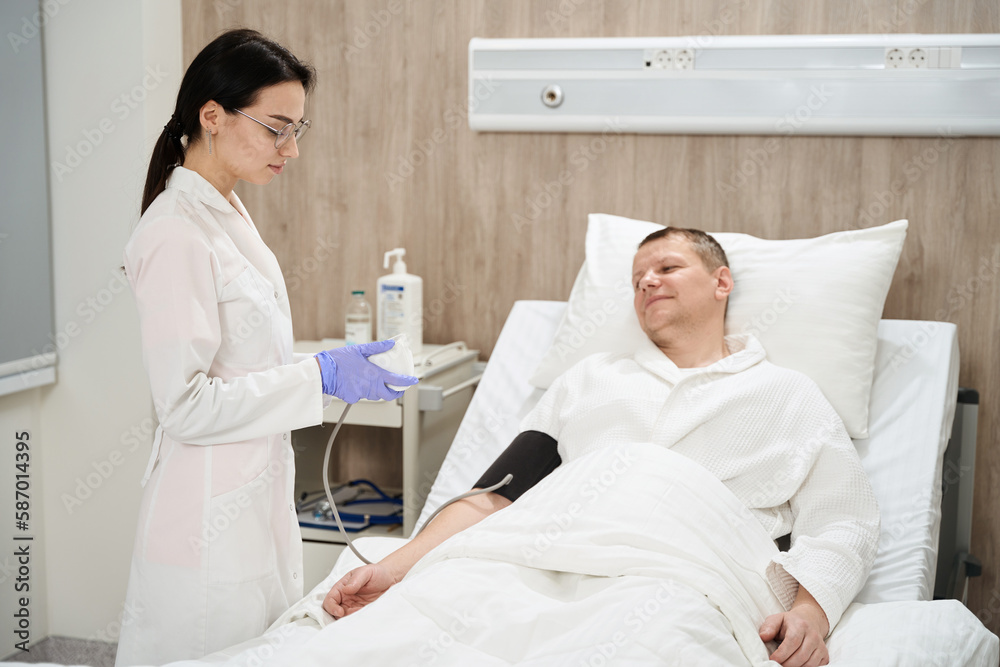 Elegant nurse is monitoring blood pressure in the clinic Elegant nurse is monitoring blood pressure in the clinic