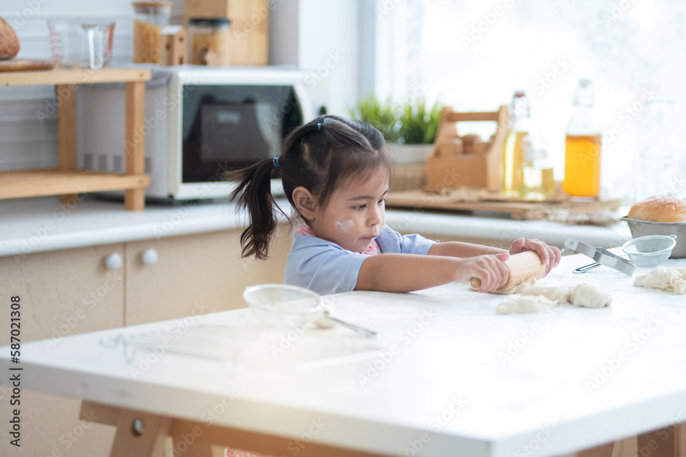 Little cute girl enjoy make bakery in kitchen, Little girl playing with flour, use rolling pin kneading bread dough Little cute girl enjoy make bakery in kitchen, Little girl playing with flour, use rolling pin kneading bread dough