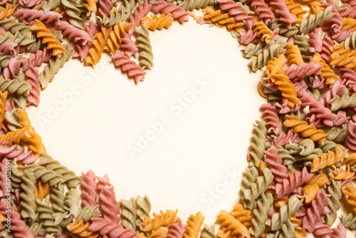 Rice vegetable pasta on a white background, laid out in the shape of a heart, a place for text. photo