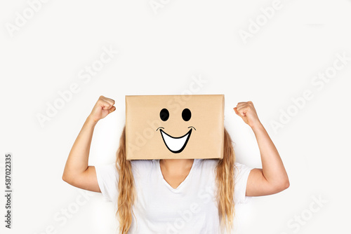 Mujer con caja en la cabeza y con los brazos en alto sobre un fondo blanco liso y aislado. Vista de frente y de cerca. Copy space