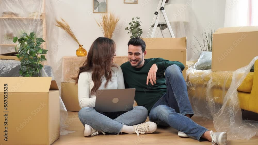 Happy couple using laptop on sofa