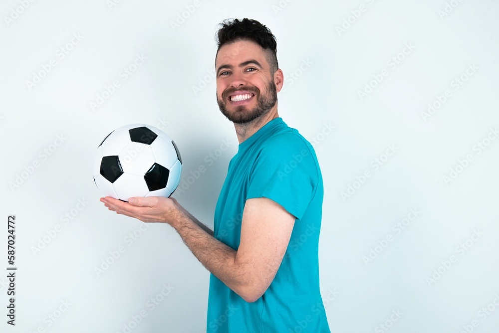 Young man holding a ball over white background pointing aside with hands open palms showing copy space, presenting advertisement smiling excited happy