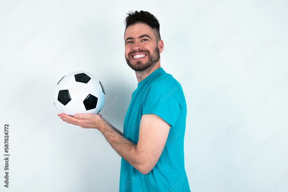 Young man holding a ball over white background pointing aside with hands open palms showing copy space, presenting advertisement smiling excited happy Young man holding a ball over white background pointing aside with hands open palms showing copy space, presenting advertisement smiling excited happy