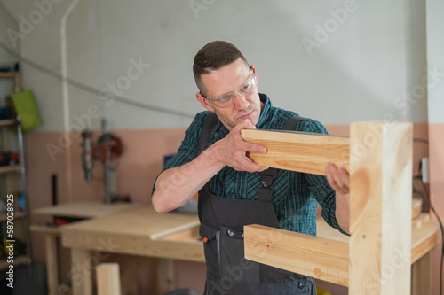Caucasian man measuring the level of table legs. 