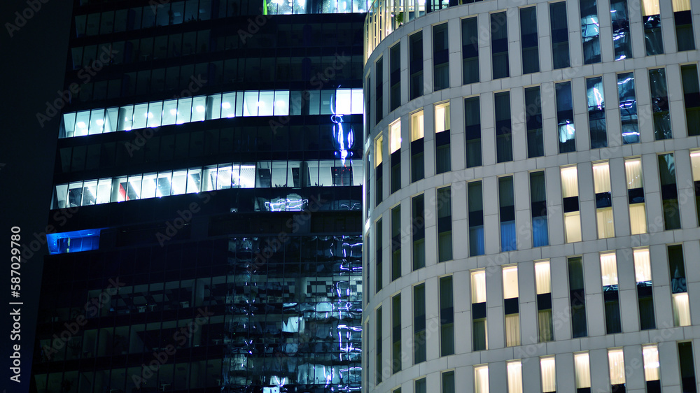Pattern of office buildings windows illuminated at night. Glass architecture ,corporate building at night - business concept. Blue graphic filter. Pattern of office buildings windows illuminated at night. Glass architecture ,corporate building at night - business concept. Blue graphic filter.
