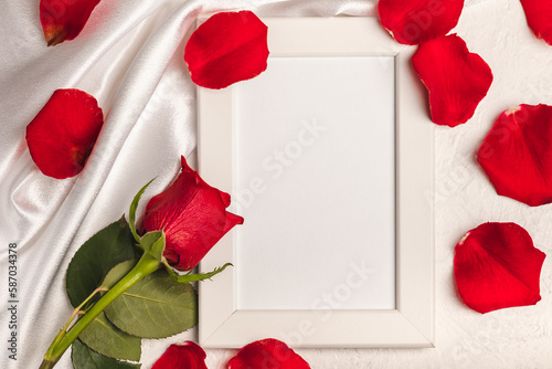 Fototapeta Naklejka Na Ścianę i Meble -  Greeting card. Frame and red rose with scattered petals on a white background.