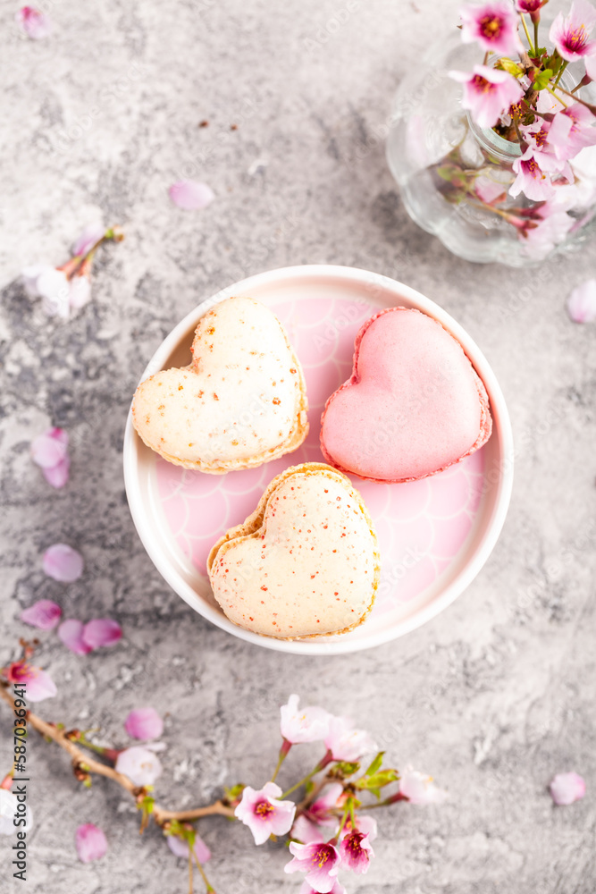 Macarons or French macaroons in heart shapes with cherry blossom branch for Mothers Day Macarons or French macaroons in heart shapes with cherry blossom branch for Mothers Day