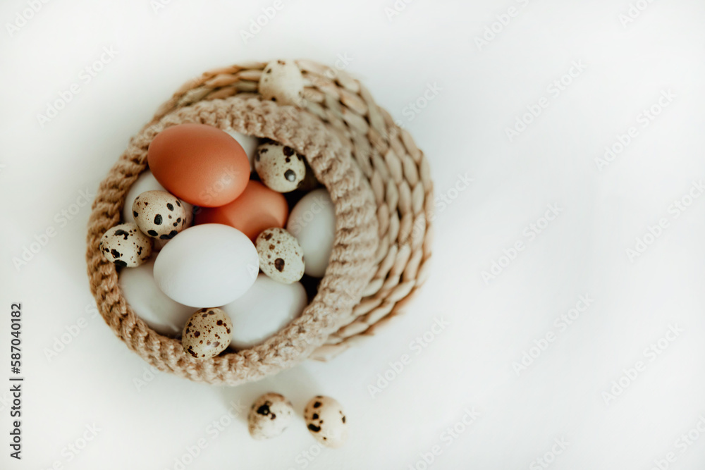 Easter white and brown eggs in a basket with flowers on a white background Easter white and brown eggs in a basket with flowers on a white background