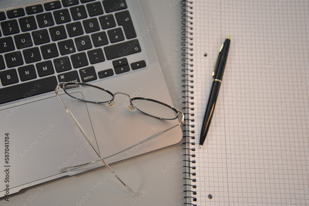 laptop, notepad and glasses on gray surface laptop, notepad and glasses on gray surface