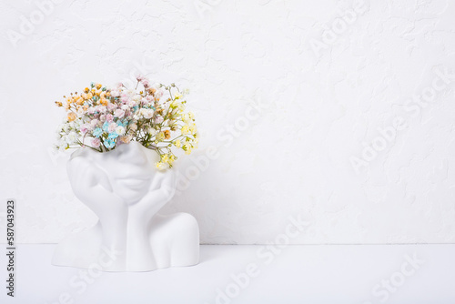 Creative plaster vase head-shape with colorful flowers. Mind care concept. Copy space