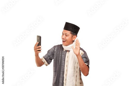 A man in Muslim attire with a white sal around his neck is holding a phone and smiling. isolated on white background photo