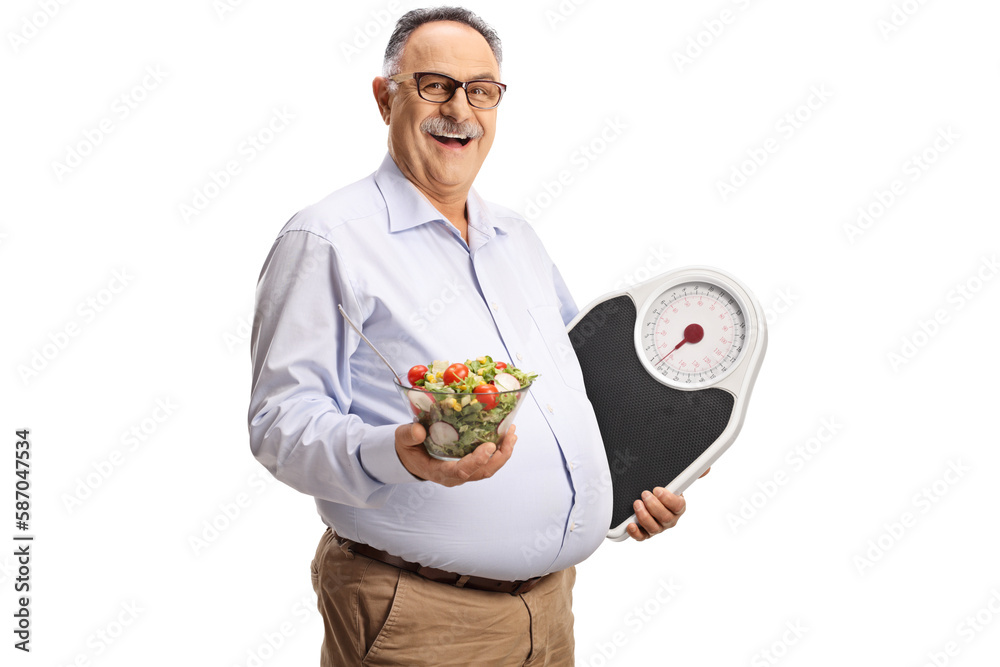 Mature man holding a salad and a weight scale Mature man holding a salad and a weight scale
