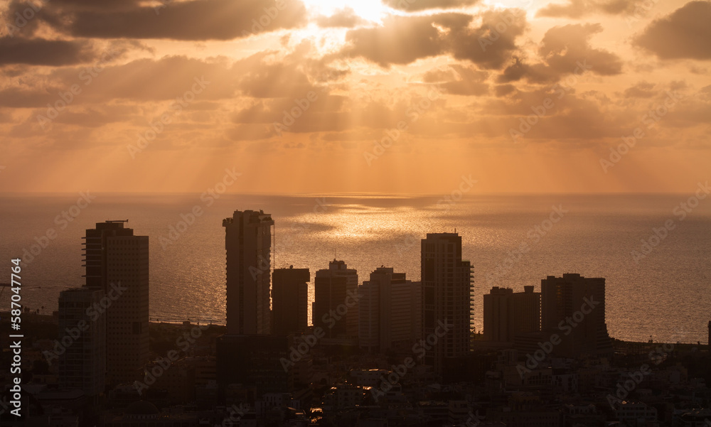 Sunset above Tel Aviv panorama. Sunrays on the sea surface and high-rises