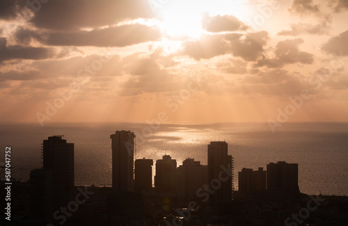 Sunset above Tel Aviv. Sunrays on the sea surface and high-rises