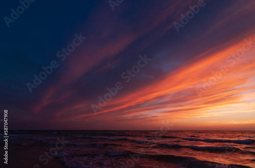 Sunset over the sea shore, sandy beach, colorful sky