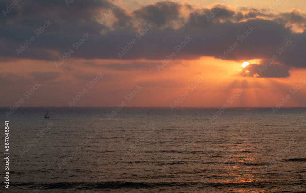 Sea panorama. Sailboat goes on the waves during sunset