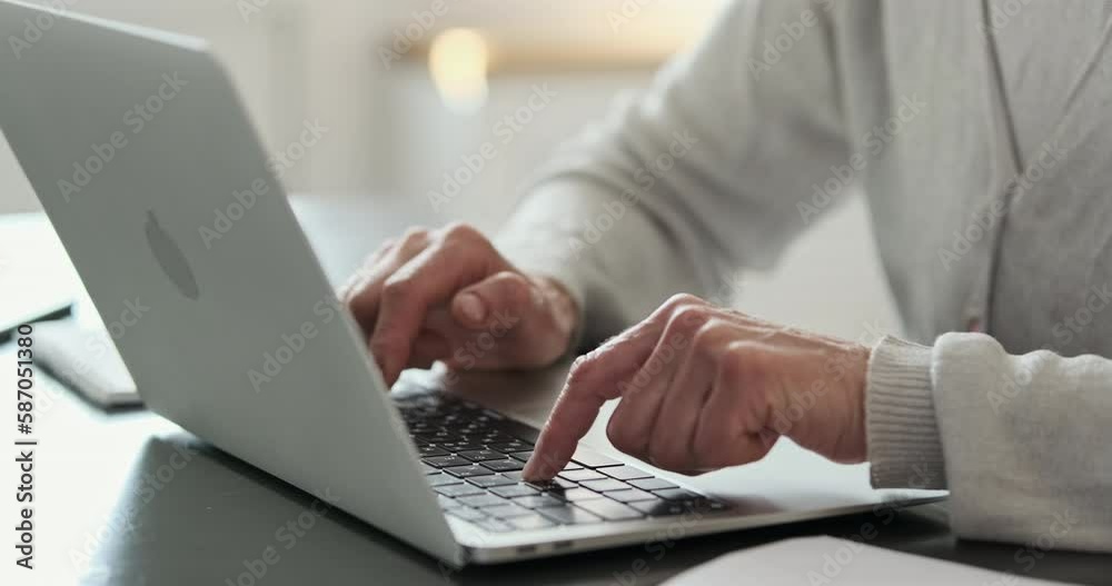 Elderly woman is slowly typing on the laptop keyboard with her index fingers. Side view, close-up, unrecognizable Elderly woman is slowly typing on the laptop keyboard with her index fingers. Side view, close-up, unrecognizable