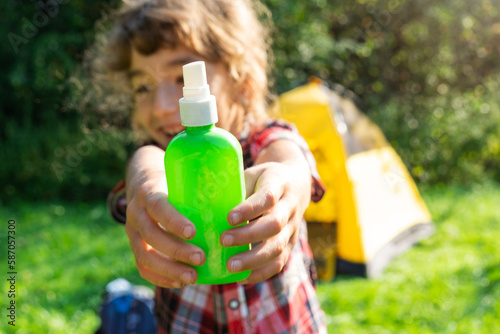 Girl uses a remedy for mosquitoes and biting insects in nature. Protection of the skin from tick bites, gadflies, blood-sucking pests, a means for children without allergens for outdoor camping