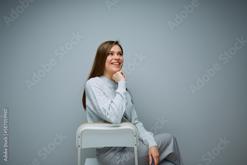Portrait of woman sitting on chair leans on her srm and looks forward. © Yuriy Shevtsov