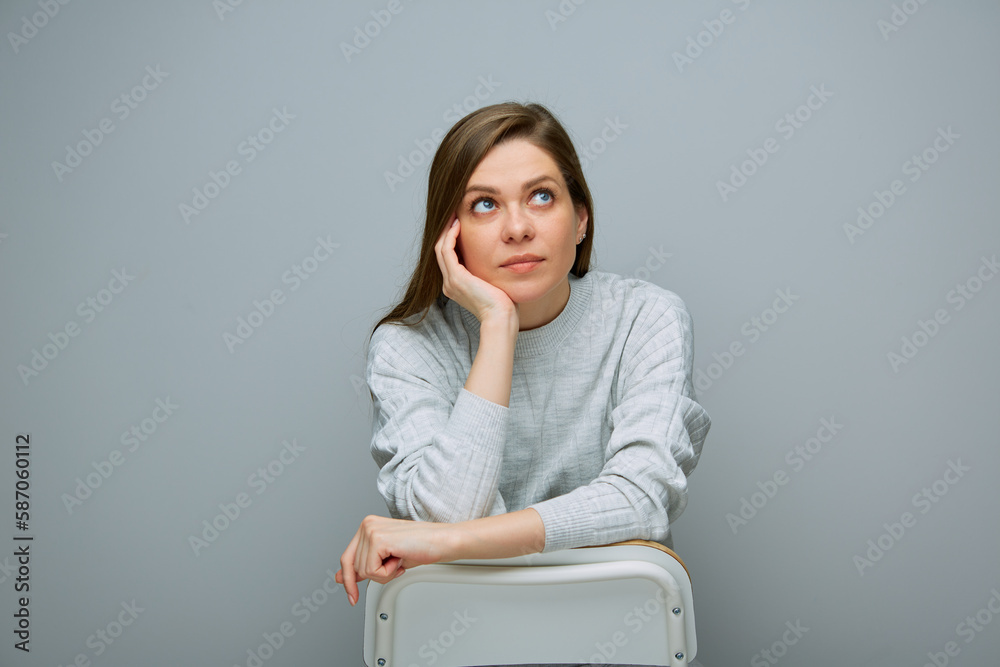 Portrait of relaxed dreaming woman sitting on white chair and looks up. Portrait of relaxed dreaming woman sitting on white chair and looks up.