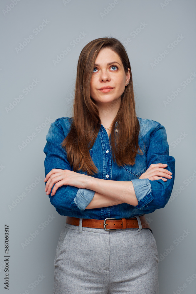 Serious woman in casual blue shirt looking up, isolated portrait.