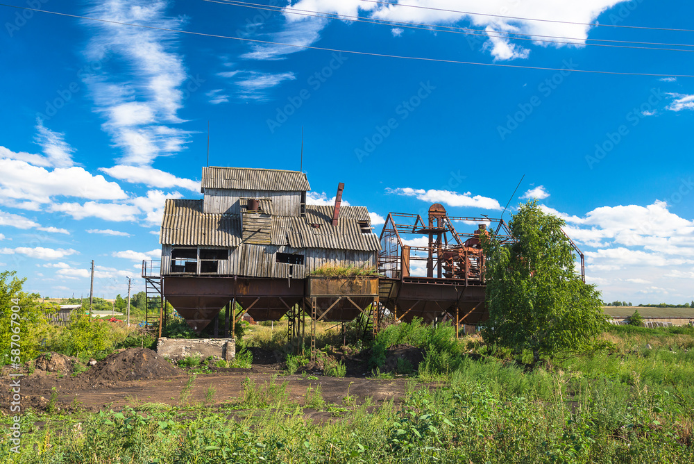 Fototapeta premium Old abandoned kolkhoz wooden grain elevator on the sunny summer day