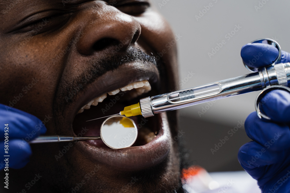 Anesthesia syringe injection closeup. Dentist injects syringe with