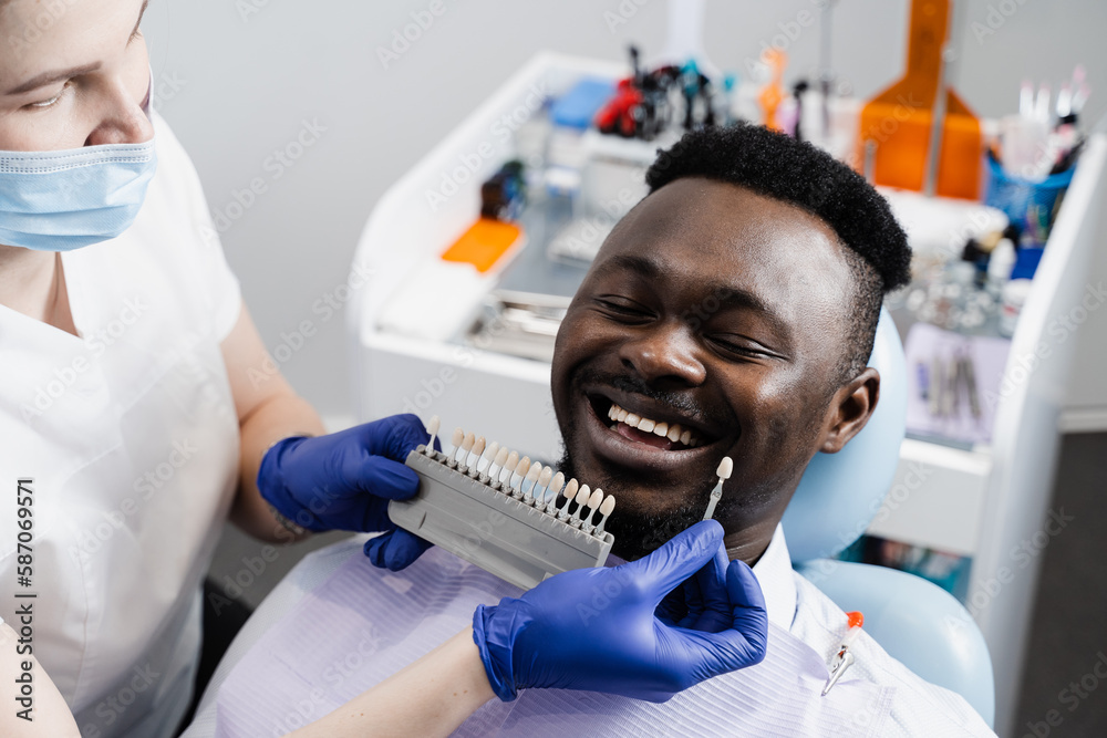 Dentist showing teeth color shades guide for tooth whitening for