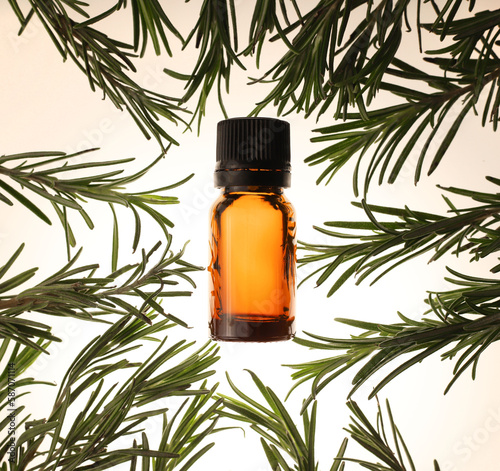 fragrant medicinal evergreen rosemary on a light background with a transparent glass and a jar of hair oil. medical plant rosemary for stress anxiety and more